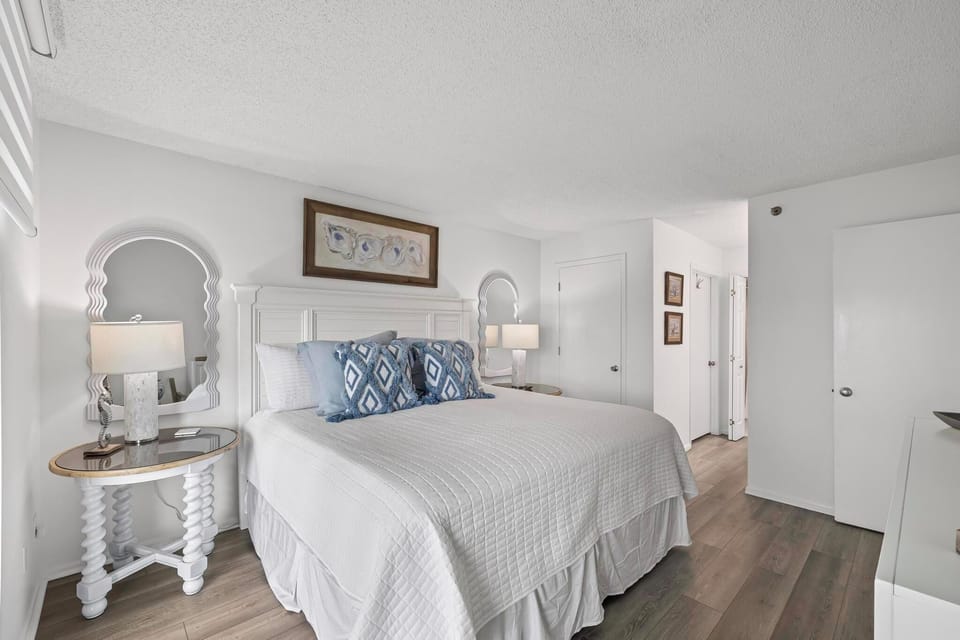 Elegant bedroom with white linens and coastal-theme decor.