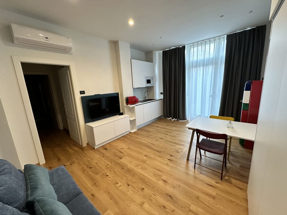 Living room on ground floor with kitchenette, closet with fold-down bed, and TV with SKY