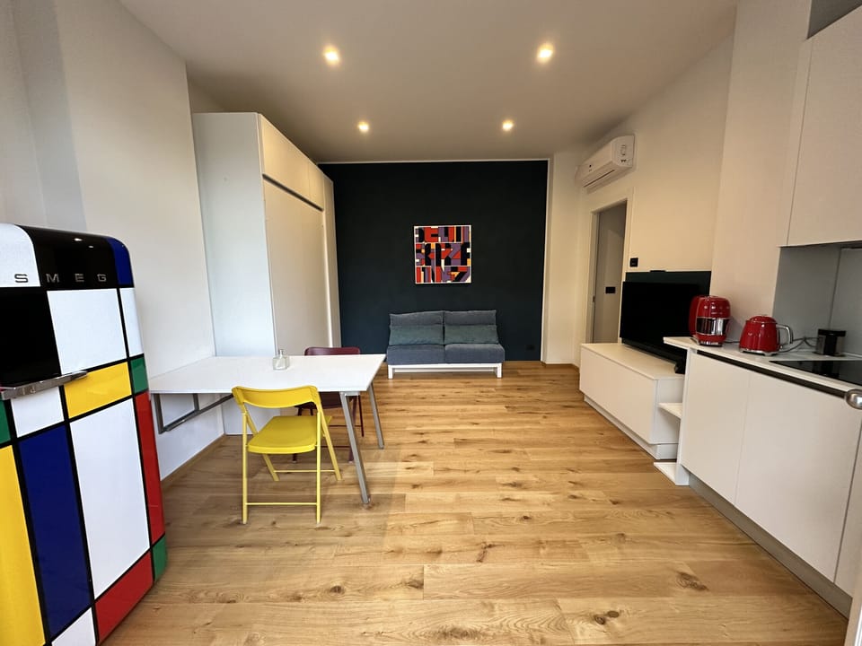 Living room on ground floor with kitchenette, closet with fold-down bed, and TV with SKY