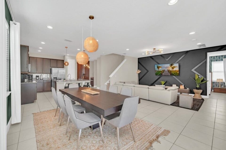 Spacious open-plan living area with a modern kitchen, large dining table, and a cozy lounge, perfect for family gatherin