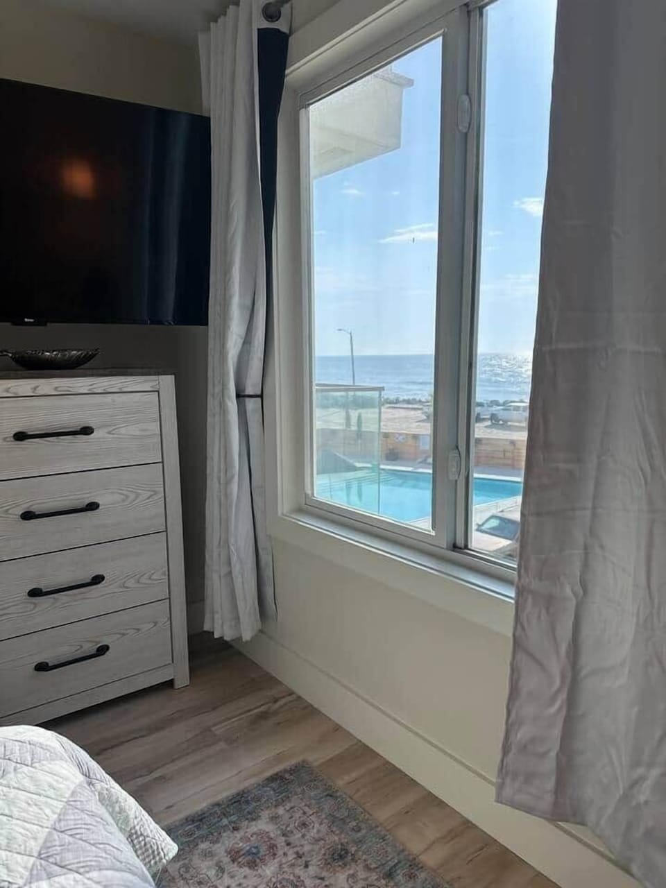 Queen bedroom with Smart TV, bedside lighting, and coastal-inspired décor.
