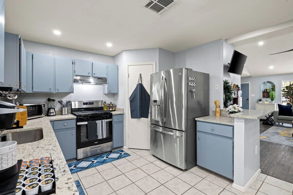 Whip up culinary masterpieces in this blue-cabinet kitchen with stainless appliances!