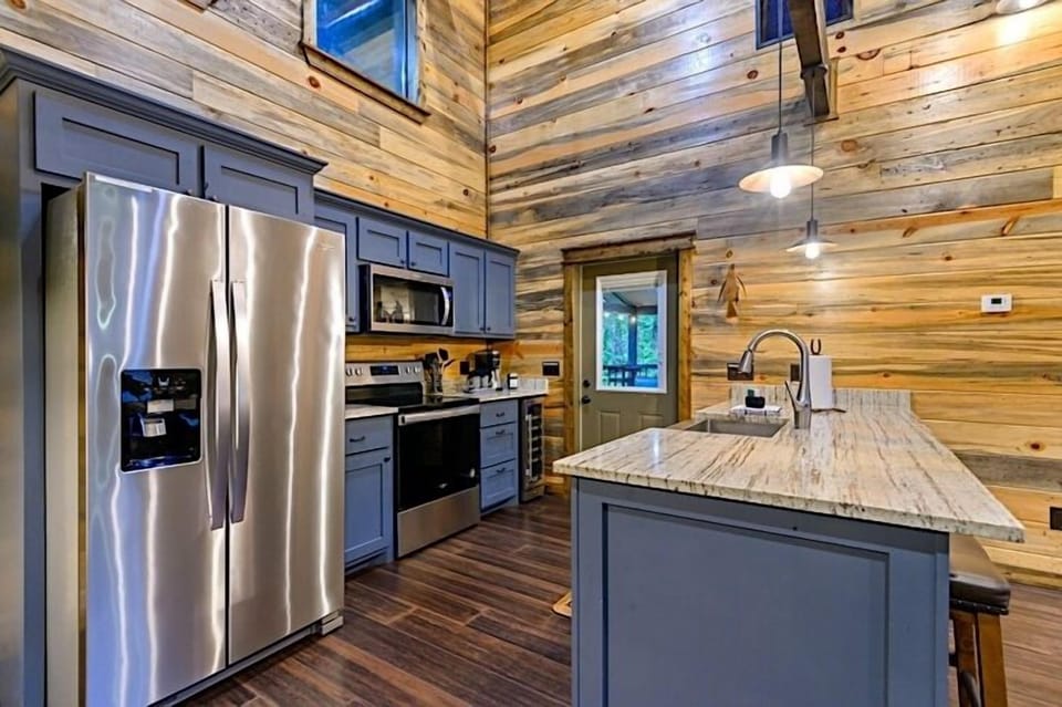 Full kitchen with stainless appliances and farm house sink as well as a bar area for added counter space