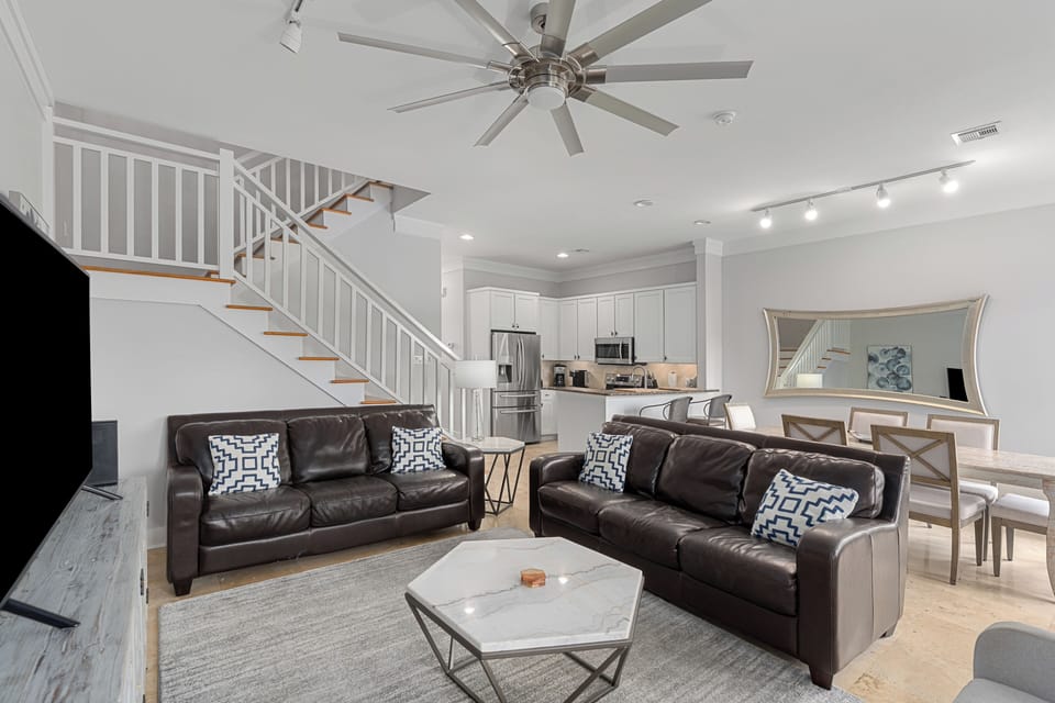 Open living room with vaulted ceilings, sleek furnishings, and bright natural light.