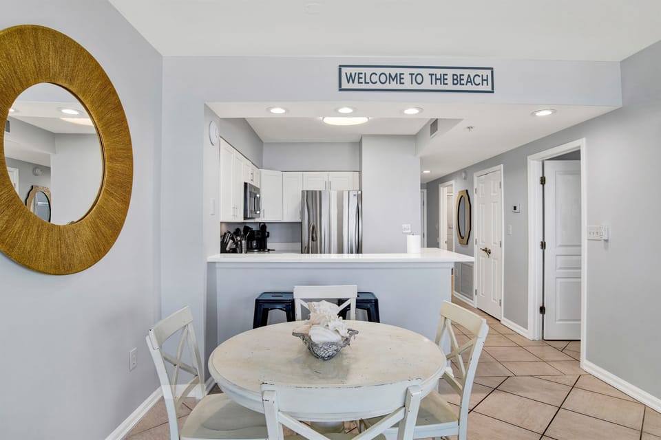 Dining area with table and 4 chairs and breakfast bar seating for 2