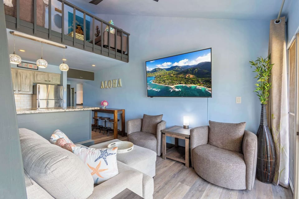 Relax in our stylish Living Room - With Loft above, featuring a large smart TV and seamless flow to the kitchen, perfect for your island getaway.