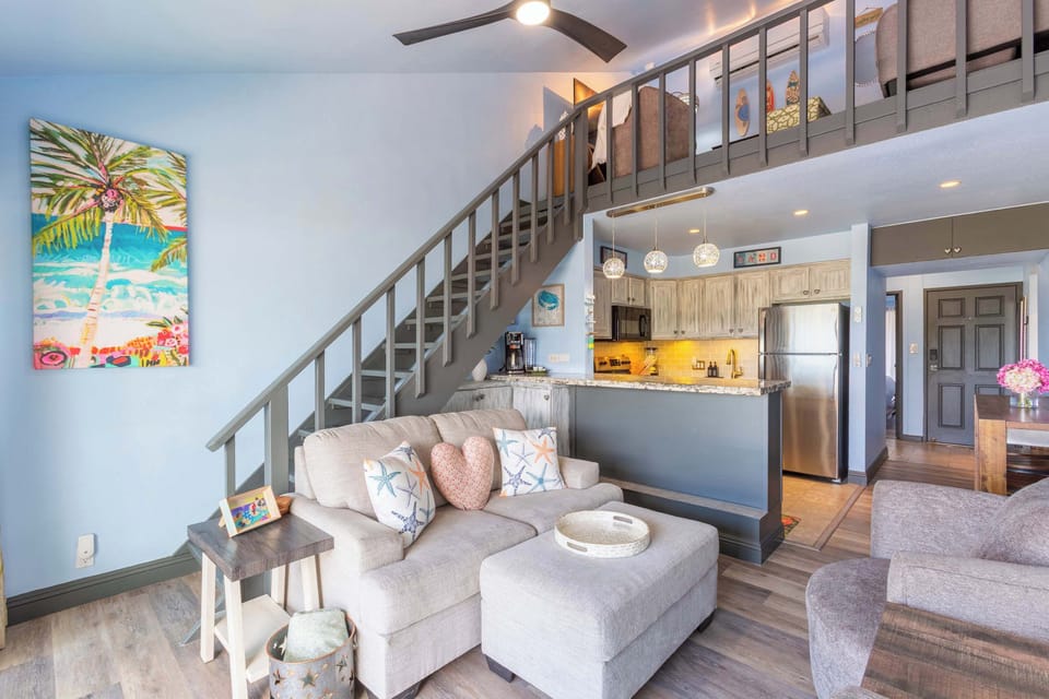 Brighten up your trip to Maui! Our inviting open-concept living area, with its cozy seating and modern kitchen, is your perfect island retreat.