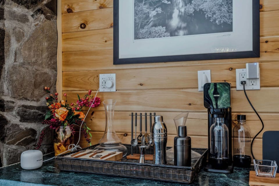 Cocktail corner stocked with wine tools, a SodaStream, and fresh flowers