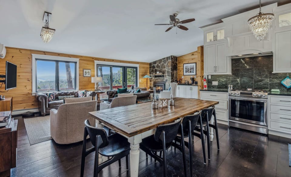 Dining for eight at the farmhouse table with the full kitchen and living room beyond