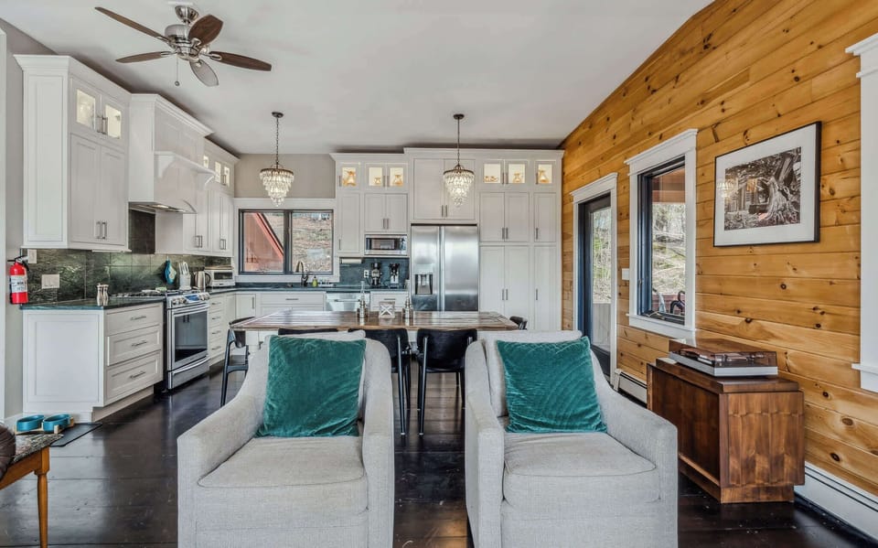 Kitchen and dining area with farmhouse table, crystal chandeliers, and a vintage record player