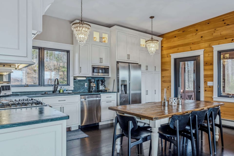 Fully equipped kitchen with stainless steel appliances, coffee station, and crystal chandeliers
