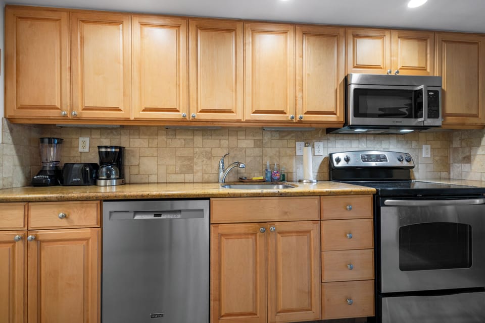 Your fully equipped kitchen with stainless steel appliances, warm wood cabinetry, and plenty of counter space makes preparing meals feel effortless and homey.