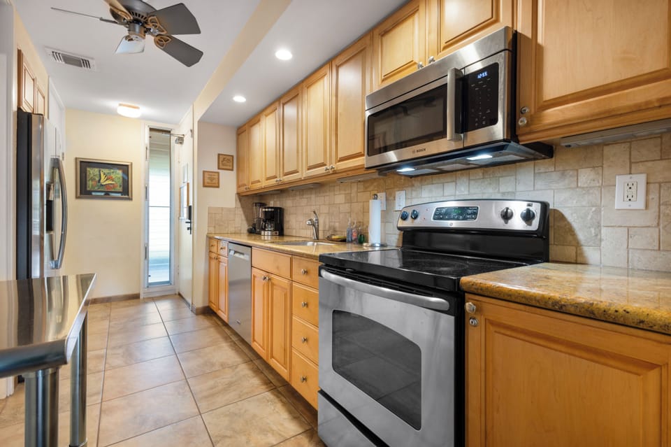 Your fully equipped kitchen features everything needed to prepare delicious meals, with modern appliances, ample counter space, and warm wood cabinetry creating a welcoming space for cooking and gathering.