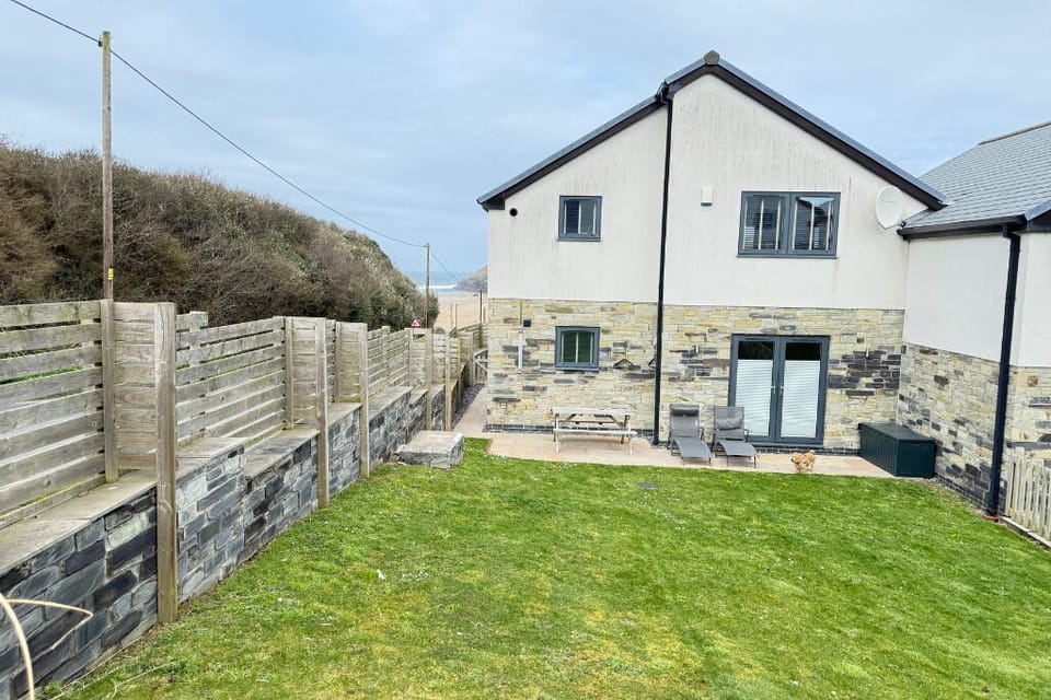 Rear enclosed garden with outdoor shower, table and benches