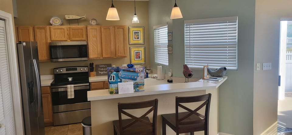 Fully stocked kitchen with modern appliances and casual breakfast bar seating.