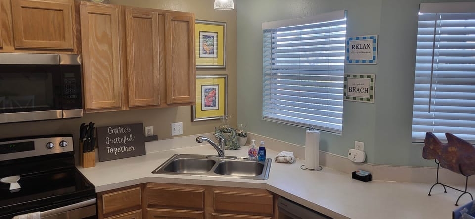 Light-filled kitchen with double sink, generous counters, and beach-inspired accents.