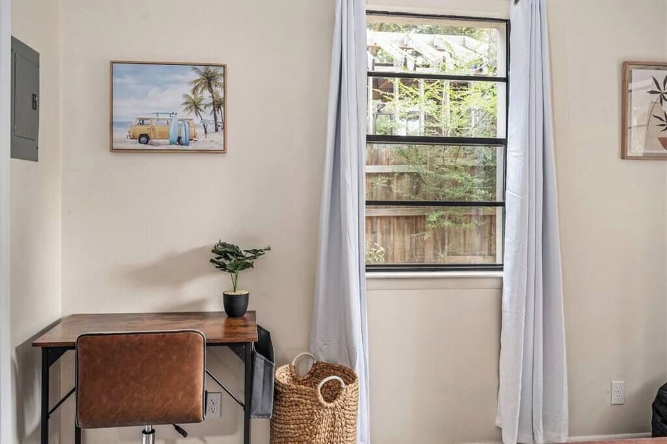 Cozy bedroom corner w/ desk setup & window light, ideal for quiet moments or work