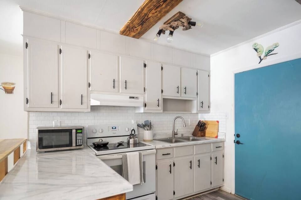 Bright kitchen w/ white cabinetry, modern appliances & plenty of counter space