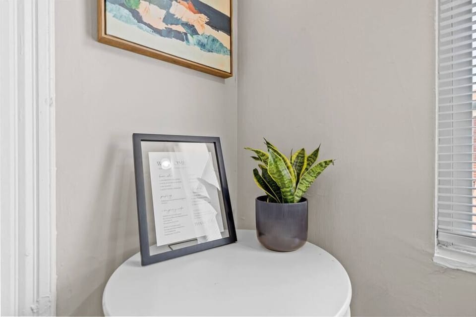 A small entryway table decorated with a plant and artwork creates a warm first impression. This welcoming corner sets the tone for the home’s modern charm.