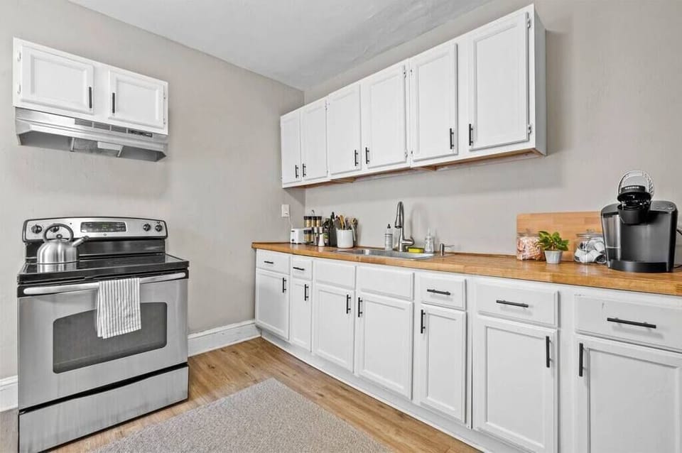 A fully equipped kitchen with stainless steel appliances and crisp white cabinetry. It offers ample counter space for cooking and meal preparation.