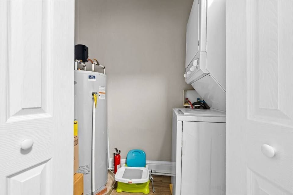 Neatly organized laundry area w/ washer, dryer & storage space