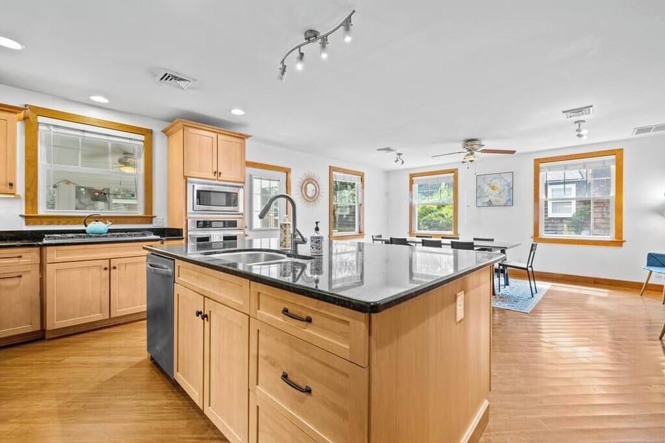Modern kitchen w/ central island, warm cabinetry & sleek finishes