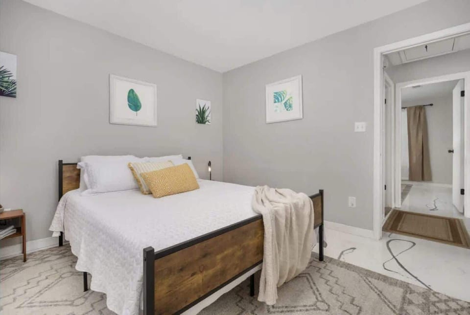 Bright bedroom w/ large window, soft textures & calming decor