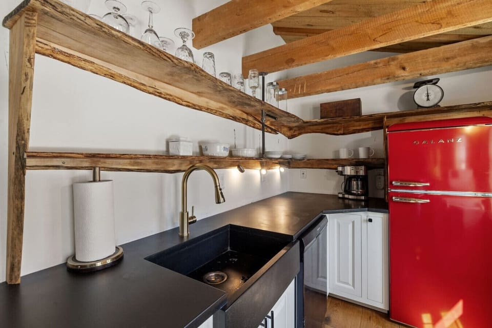 This kitchen features a retro red refrigerator, open shelving, and all the cookware you need