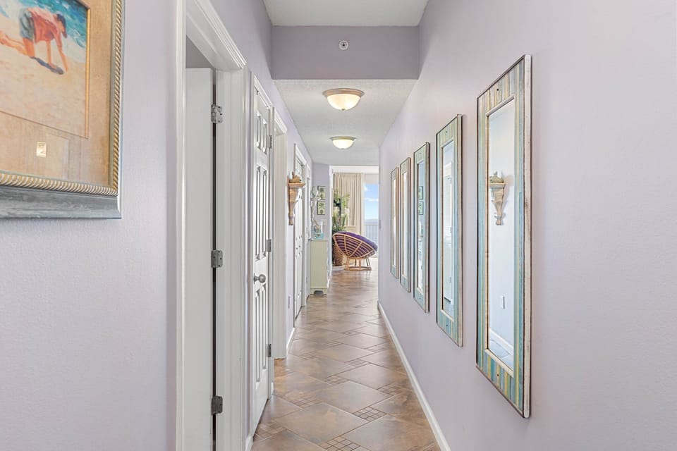 Hallway leading through the condo w/ crisp walls & an open, airy feel.