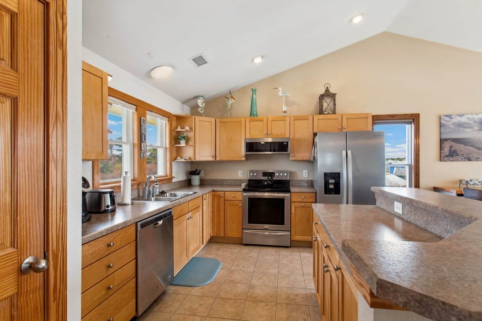 The well-appointed Kitchen features stainless steel appliances and a wine fridge, seamlessly flowing into the dining area for easy entertaining.