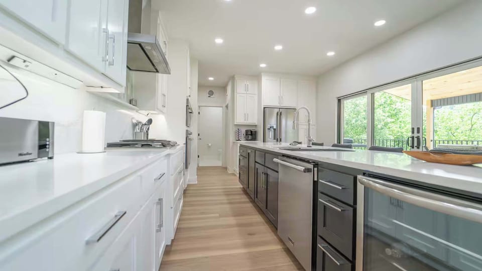 A symphony of sleek surfaces and natural light. Modernity redefined in this pristine kitchen. 