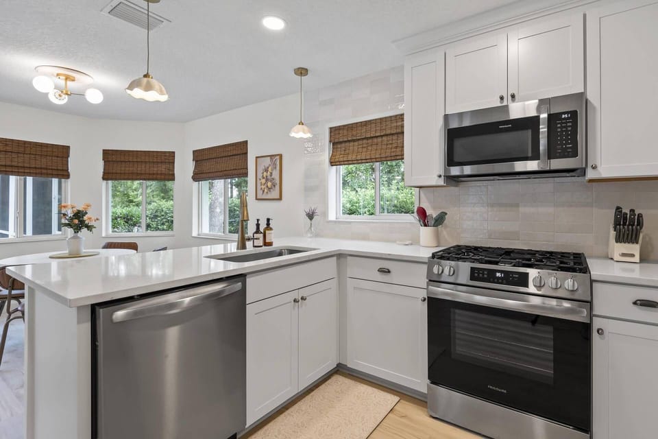 Stocked kitchen with all the essentials, offering views of the breakfast nook, dining area, and the outdoor patio and pool for effortless entertaining