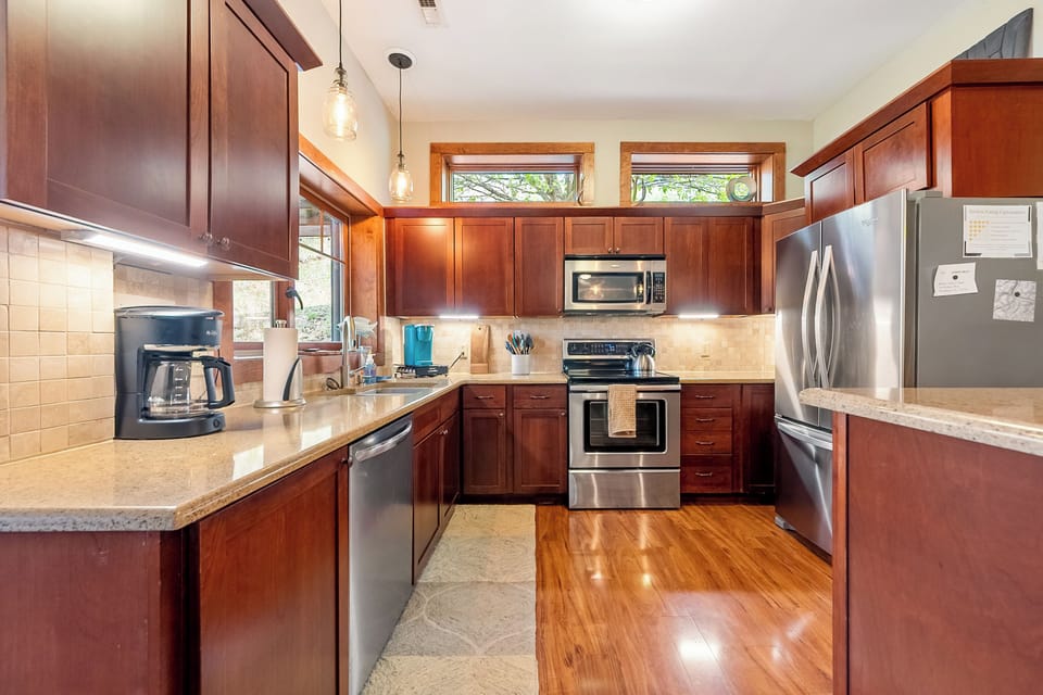 Modern kitchen with stainless steel appliances and coffee station.
