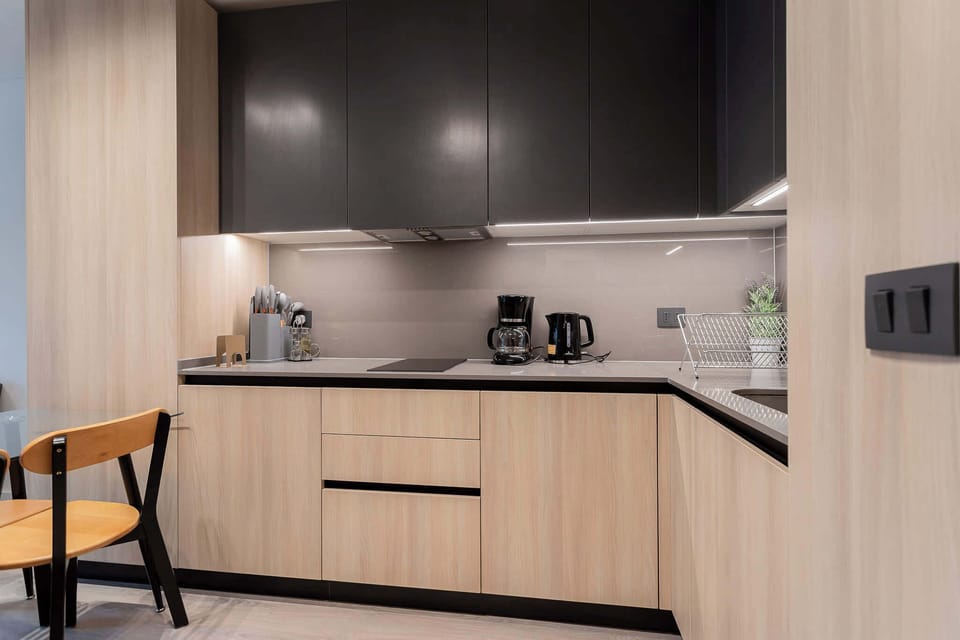 Experience a sleek, modern kitchen with stylish cabinetry and essential amenities for a comfortable stay.