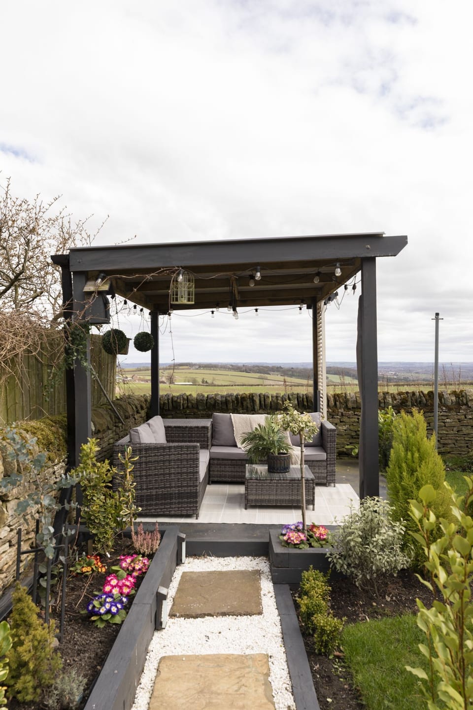 Pigswood Cottage - comfy seating and garland lights beneath the pergola