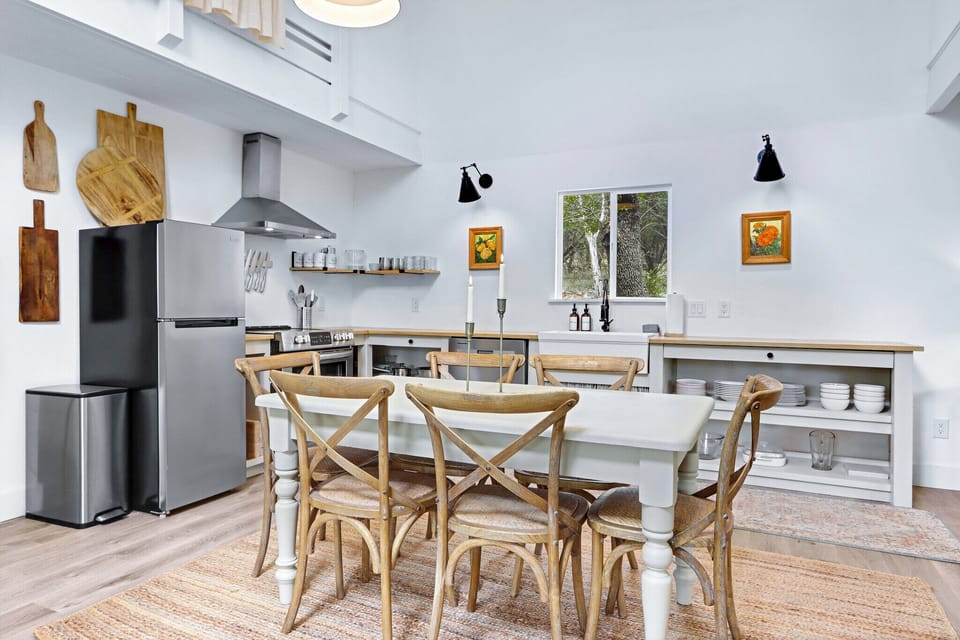Closer view of the dining table with the kitchen beyond.