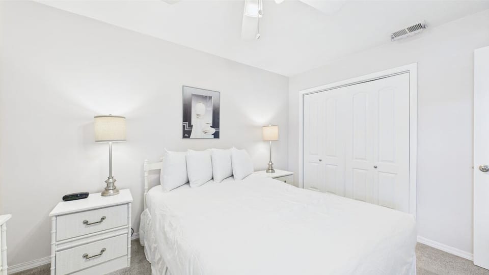Primary bedroom with queen bed TV and balcony access