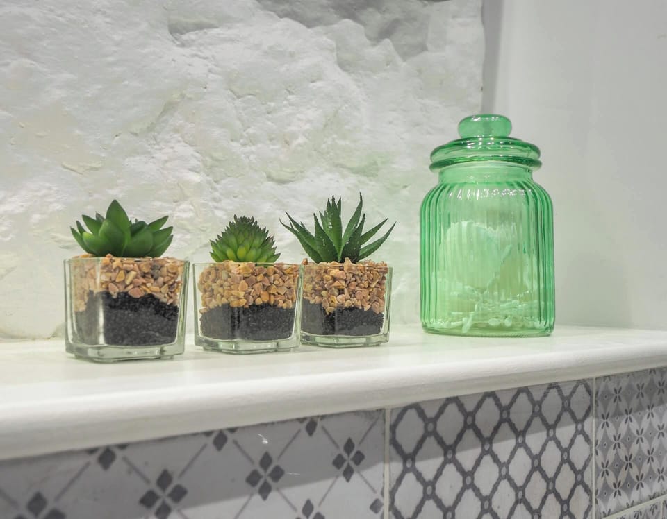 Mini glass flower pots on the bathroom counter.