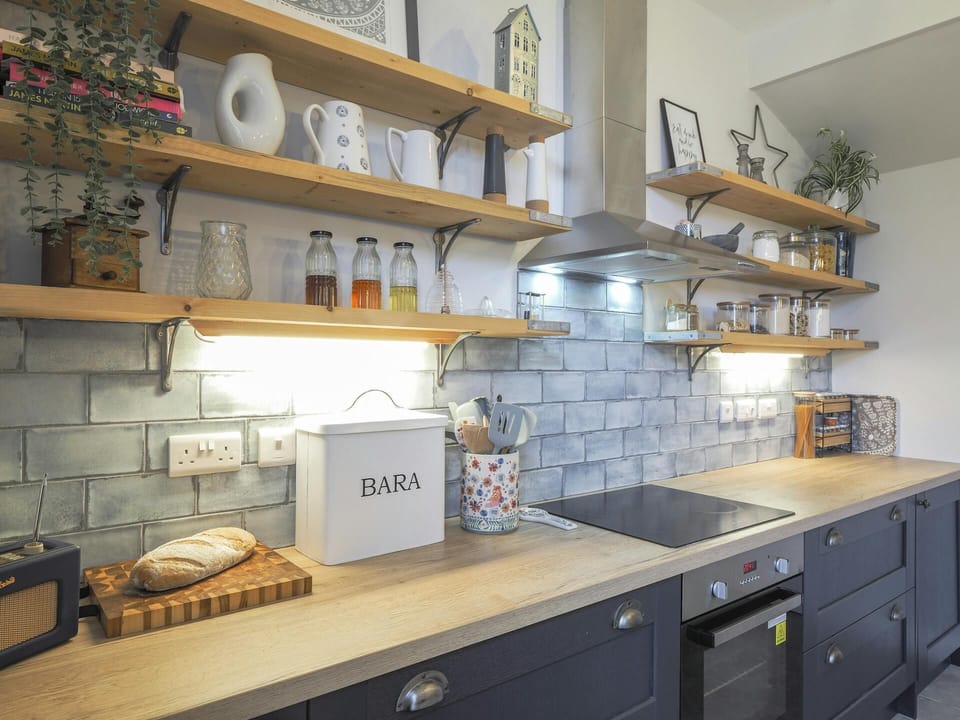Kitchen with wooden shelves and built in hob.