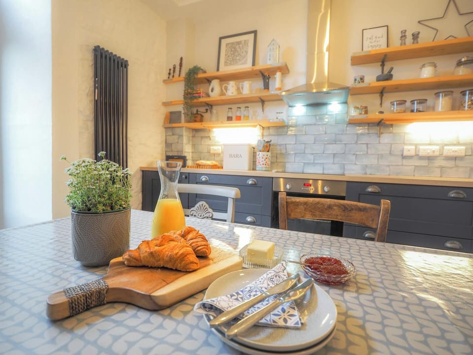 Dining table with plates and cutley on top in the kitchen.