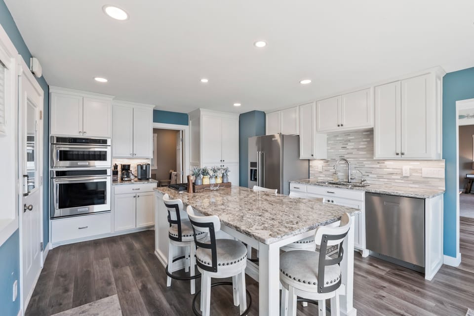 Spacious kitchen with dining area, modern appliances and natural light.