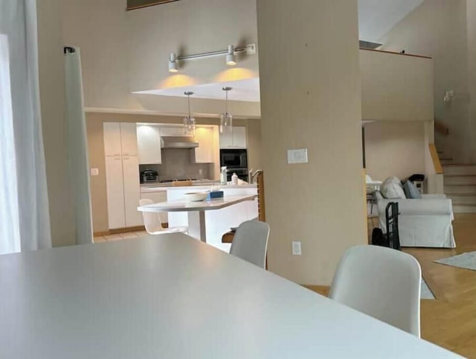 [Main Level]  Open concept kitchen.  Washer/dryer to the left, living room to the right.   Outdoor seating on deck to the left. 