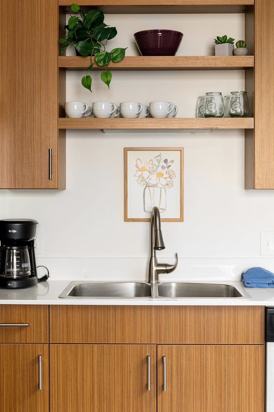 Kitchen sink station w/ modern faucet, open shelving & coffee maker at the ready.