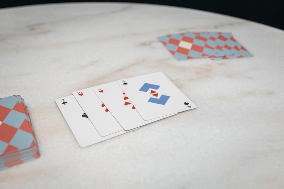 A set of playing cards arranged on a smooth marble surface for a casual game.