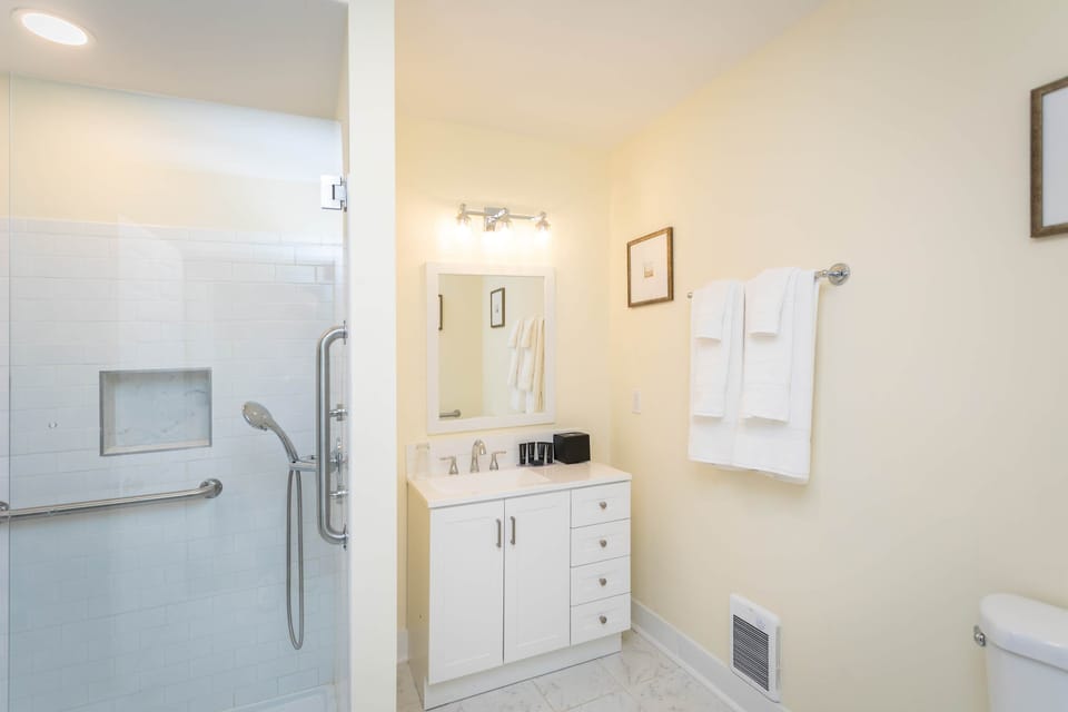 Modern bathroom with a glass-enclosed shower and white vanity.