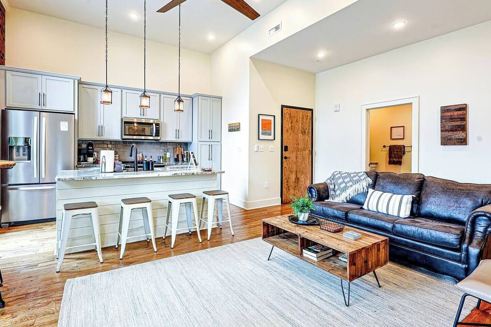 Charming Living Room: Relax in style with a sleek sofa and open kitchen island perfect for gatherings!