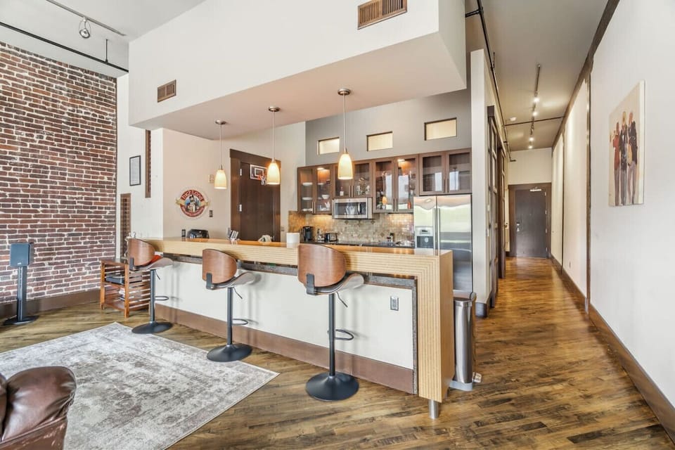 Kitchen & Dining: Stylish bar seating with modern appliances and charming exposed brick accents!