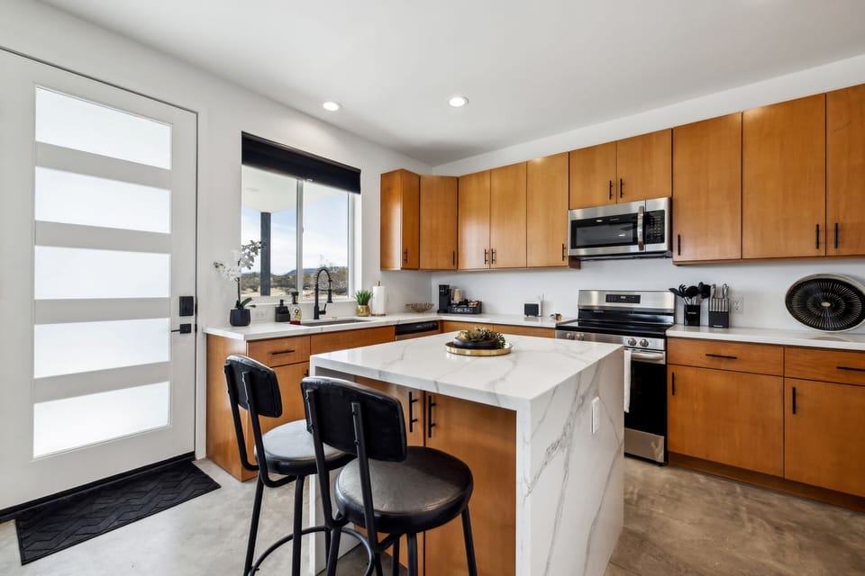 Large modern kitchen: stove, oven, island seating, microwave & dishwasher.