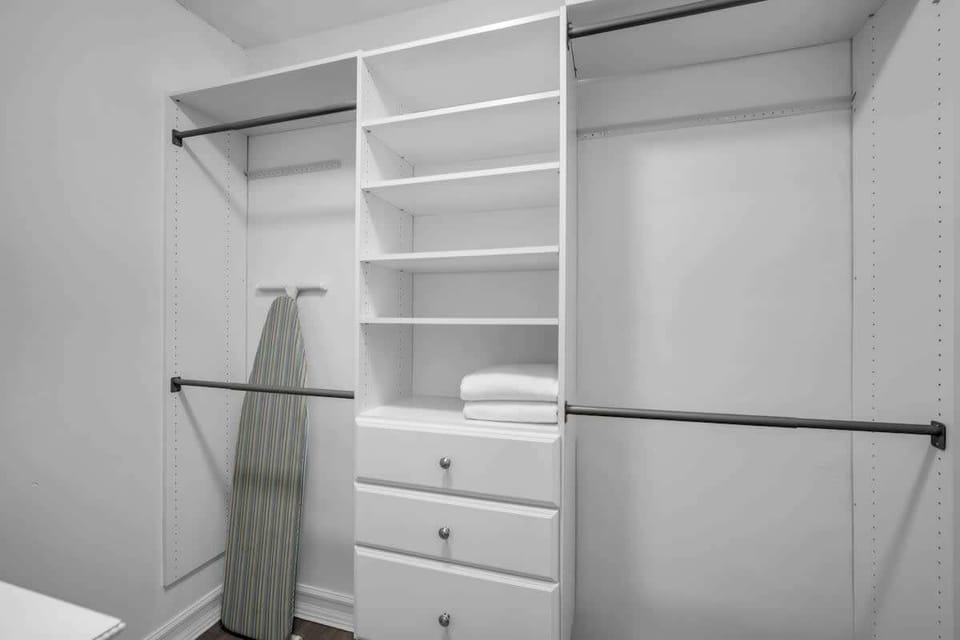 Stay organized with this spacious walk-in closet—plenty of shelving, hanging space, and even an ironing board to keep you looking sharp.