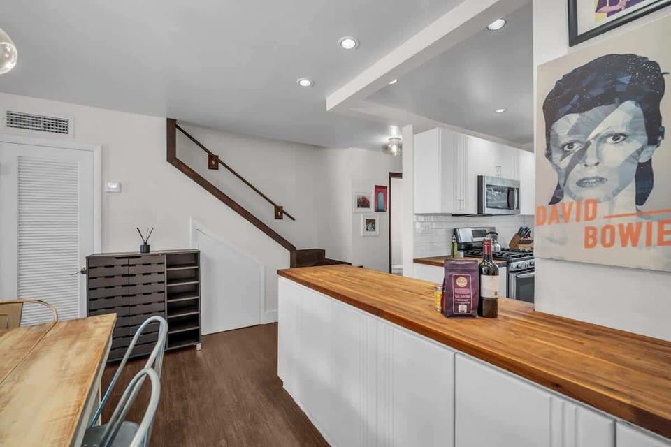 Step into style with this eclectic and inviting space, where bold art meets modern charm. The open layout flows from kitchen to dining, making it perfect for sharing meals, music, and memories.